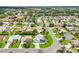 Gorgeous aerial view of homes with well-manicured lawns, lush trees, and beautiful landscaping in a desirable neighborhood at 2455 Five Forks Trl, The Villages, FL 32162