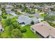 Scenic shot of a gray roofed house with enclosed screened-in lanai and lush trees at 2455 Five Forks Trl, The Villages, FL 32162