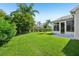 Serene backyard featuring lush green grass and a covered lanai for outdoor enjoyment at 2455 Five Forks Trl, The Villages, FL 32162