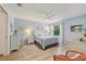 Serene bedroom featuring a comfortable bed, light blue walls, and ample natural light from the window at 2455 Five Forks Trl, The Villages, FL 32162