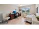 Bright bedroom with a desk, chair, and a view of the community outside the window at 2455 Five Forks Trl, The Villages, FL 32162