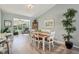 Elegant dining room with hardwood floors, a six seat table, and natural light at 2455 Five Forks Trl, The Villages, FL 32162