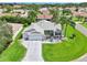 Beautiful home showcasing meticulous landscaping, a gray roof, and a spacious three-car driveway at 2455 Five Forks Trl, The Villages, FL 32162
