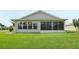 Charming home featuring a covered lanai and a lush green yard at 2455 Five Forks Trl, The Villages, FL 32162