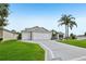 Inviting single-story home with a three car garage, well-kept lawn, and beautiful landscaping at 2455 Five Forks Trl, The Villages, FL 32162