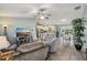 Open-concept living room featuring modern furnishings, a ceiling fan, and light, airy paint at 2455 Five Forks Trl, The Villages, FL 32162