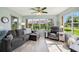 Sunlit living room featuring a comfortable sofa, accent chair, and large windows with a view at 2455 Five Forks Trl, The Villages, FL 32162