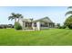 Well-maintained home featuring a screened lanai and lush landscaping on a neatly manicured lawn at 2455 Five Forks Trl, The Villages, FL 32162