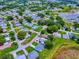 Aerial view of a community with homes and mature trees, showcasing the neighborhood's layout and surroundings at 25007 Bellevue, Leesburg, FL 34748