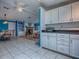 Modern kitchen with white cabinets and tiled backsplash, and a view of the living room at 25007 Bellevue, Leesburg, FL 34748