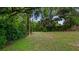 Spacious backyard offers a serene setting with mature trees and ample space for outdoor activities at 256 Carroll St, Clermont, FL 34711