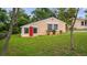 Charming home with a vibrant red door, well-manicured lawn, and tasteful landscaping at 256 Carroll St, Clermont, FL 34711