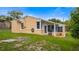 Charming home's rear exterior boasts a cozy screened patio and well-maintained lawn at 256 Carroll St, Clermont, FL 34711