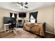 Bedroom with laminate floors, ceiling fan, and two workspaces with computers at 25824 Shawnee St, Sorrento, FL 32776