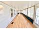 Long sunroom with hardwood floors, windows, and sheer curtains at 2585 Karen Dr, Mount Dora, FL 32757