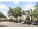 Condo exterior with ample parking and mature landscaping providing shade to the front of the building at 2639 Maitland Crossing Way # 102, Orlando, FL 32810