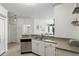View of kitchen area with sink, white cabinets, and adjacent dining/living space at 2639 Maitland Crossing Way # 102, Orlando, FL 32810