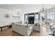 Bright living room featuring modern light fixtures, stylish furniture, and sliding glass doors to the balcony at 2639 Maitland Crossing Way # 102, Orlando, FL 32810