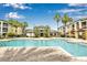 Community pool with lounge area surrounded by palm trees, landscaping and community buildings at 2639 Maitland Crossing Way # 102, Orlando, FL 32810