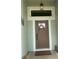 Inviting front door with overhead light fixture, attractive front door and wreath, and tiled porch area at 2648 Maymont Ct, The Villages, FL 32163