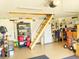 Garage interior featuring painted floor, pegboard wall, pull-down attic access ladder, and overhead garage door opener at 2648 Maymont Ct, The Villages, FL 32163