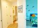 Hallway view of a bathroom and bedroom with tropical theme and decor at 2648 Maymont Ct, The Villages, FL 32163