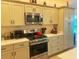 Well-lit kitchen features modern stainless-steel appliances and ample cabinet storage space at 2648 Maymont Ct, The Villages, FL 32163