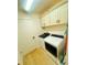 A well-lit laundry room featuring white cabinets above the washer and dryer at 2648 Maymont Ct, The Villages, FL 32163