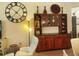 Comfortable sitting area with white chair, large clock, and decorative hutch at 2648 Maymont Ct, The Villages, FL 32163