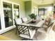 Stylish outdoor dining area with a rectangular table, comfortable chairs, and a view of the backyard at 2648 Maymont Ct, The Villages, FL 32163