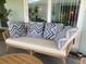 Cozy outdoor seating area with a wicker loveseat and patterned pillows at 2648 Maymont Ct, The Villages, FL 32163