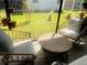 Relaxing screened porch with wicker furniture, plants, and a view of the backyard at 2648 Maymont Ct, The Villages, FL 32163