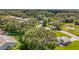Aerial view of a residential neighborhood nestled among lush green trees at 27141 Racquet Cir, Leesburg, FL 34748