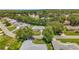An aerial view of a suburban neighborhood with well-maintained lawns and mature trees showcasing the property's location at 27141 Racquet Cir, Leesburg, FL 34748