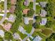Bird's-eye view highlighting the community's landscape, with tree-lined streets and pond at 27141 Racquet Cir, Leesburg, FL 34748