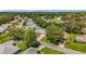 An aerial view of the neighborhood with tree-lined streets showcasing single-story homes with manicured lawns and beautiful landscaping at 27141 Racquet Cir, Leesburg, FL 34748