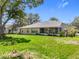 Spacious backyard view showcasing the home's exterior and beautiful green lawn at 27141 Racquet Cir, Leesburg, FL 34748