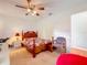 Cozy bedroom with a wooden bed frame, ceiling fan, and neutral walls creating a relaxing atmosphere at 27141 Racquet Cir, Leesburg, FL 34748