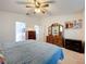 Bedroom with ceiling fan and carpet flooring and view into attached bathroom at 27141 Racquet Cir, Leesburg, FL 34748