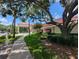 The community clubhouse features a welcoming entrance, red roof, and well-manicured landscaping at 27141 Racquet Cir, Leesburg, FL 34748