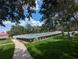 Enjoy the scenic path to the fenced community pool surrounded by lush landscaping, perfect for sunny days at 27141 Racquet Cir, Leesburg, FL 34748
