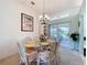 Bright dining room with glass table and chairs, with view to the outdoor patio at 27141 Racquet Cir, Leesburg, FL 34748