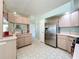 Bright kitchen featuring stainless steel refrigerator and open breakfast bar at 27141 Racquet Cir, Leesburg, FL 34748