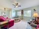 Comfortable living room featuring neutral carpet, large windows, and a ceiling fan for optimal airflow at 27141 Racquet Cir, Leesburg, FL 34748