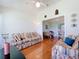 The living room has a ceiling fan, hardwood floors, an open floor plan, and a view into another room at 27141 Racquet Cir, Leesburg, FL 34748