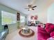 Cozy living room with neutral carpet, ample windows providing natural light, and comfortable seating arrangements at 27141 Racquet Cir, Leesburg, FL 34748