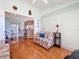 A view of the living room featuring hardwood floors, a ceiling fan, a front door view, and a breakfast bar at 27141 Racquet Cir, Leesburg, FL 34748