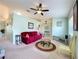 Open living room with neutral carpet, stylish lighting fixtures, and partial wall offering an airy feel at 27141 Racquet Cir, Leesburg, FL 34748