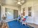 Comfortable covered patio with sliding glass doors, seating, and views of the backyard at 27141 Racquet Cir, Leesburg, FL 34748
