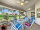 Inviting screened-in patio with ceiling fans, glass table, and views of the manicured backyard at 27141 Racquet Cir, Leesburg, FL 34748